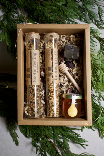 Box of natural products including honey and herbs with greenery in the background