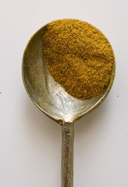 Spoon filled with Pumpkin spice powder on a white background