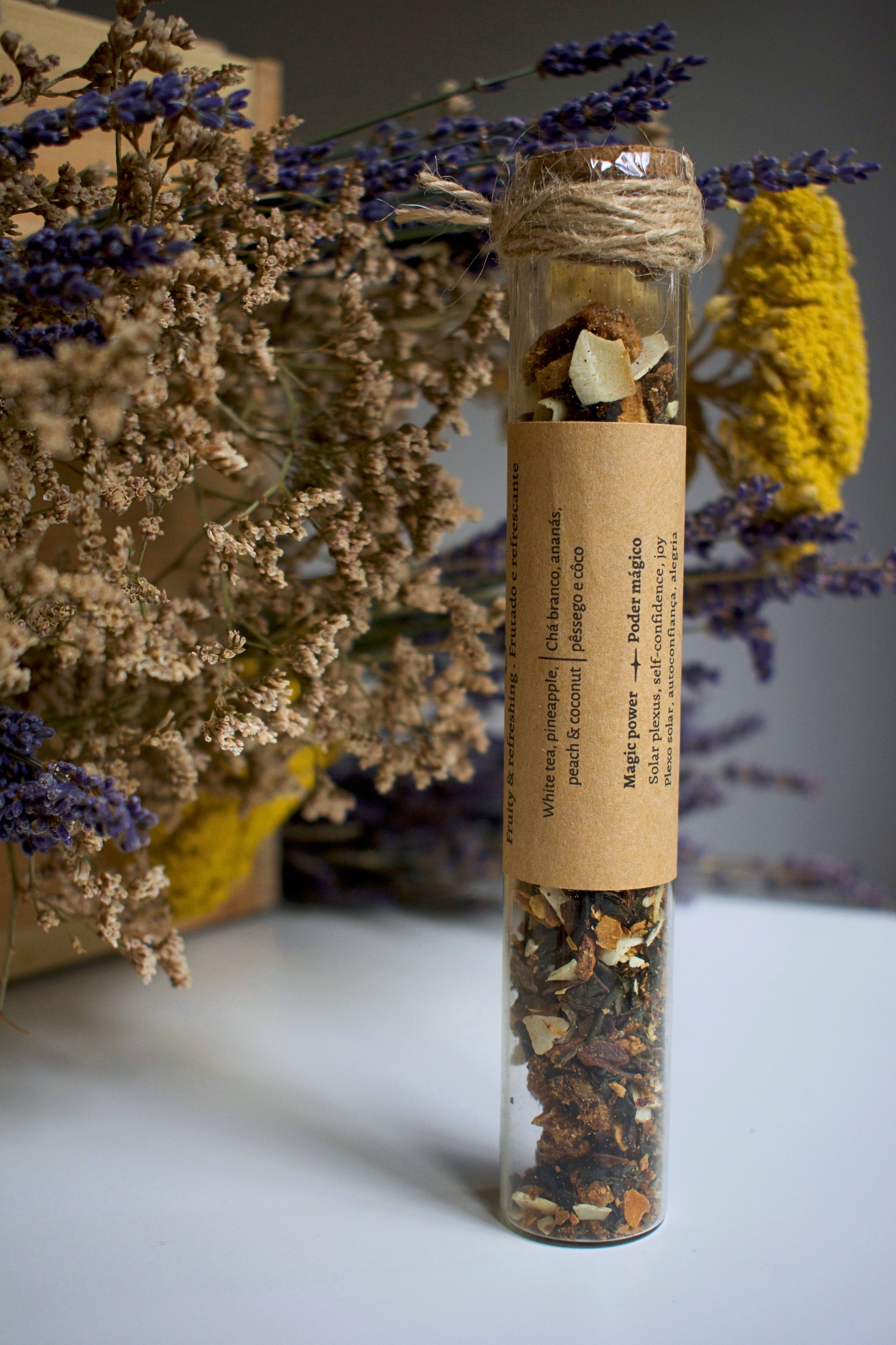 Herbal tea packaging labeled 'Midnight Sun' with dried herbs and flowers on a neutral background